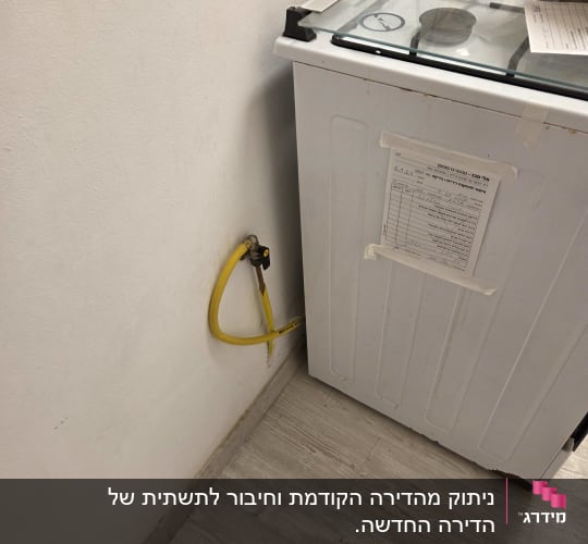 כיריים גז עם צינור גז צהוב ליד קיר